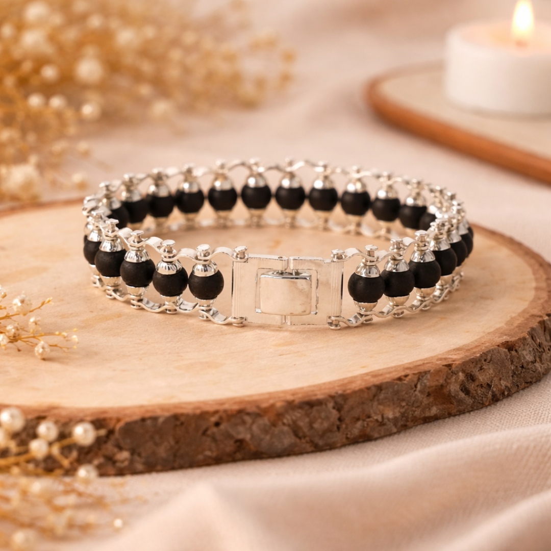 Silver and black beaded bracelet placed on a wooden tray with soft warm lighting, ideal for fashion and jewelry blog main image